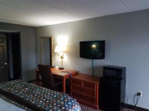 a hotel room with a bed and a desk and a television at Americas Best Value Inn St. Louis Downtown in Saint Louis