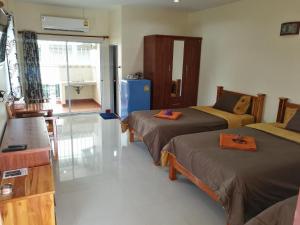 a room with two beds and a kitchen with a sink at P and P Place in Kanchanaburi