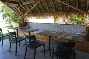 a restaurant with two tables and chairs and a table at Hôtel Atiapiti in Opoa