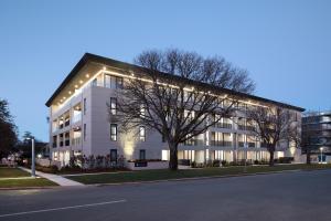 Un bâtiment blanc avec des lumières sur son côté dans l'établissement Knightsbridge Canberra, à Canberra