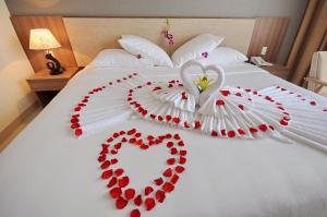 a bed with a heart made out of red pedals at Rigel Hotel in Nha Trang