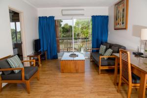 uma sala de estar com um sofá e uma mesa em Cullen Bay Resorts em Darwin