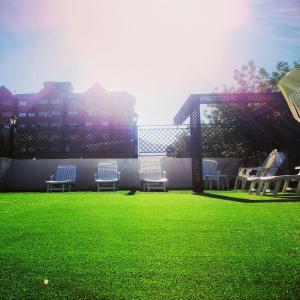 
a grassy field with lawn chairs and a tennis court at Hotel Astur in Salta
