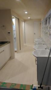 a row of white sinks in a bathroom at Base Inn Uguisudani in Tokyo