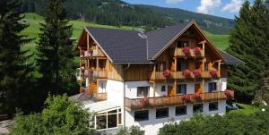 a house with flowers on the balconies of it at Garni Appartments Helvetia in Villabassa