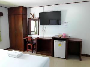 Habitación con escritorio, TV y cama. en โรงแรมฟ้าพราวฝน Fah Proud Fon Hotel en Nakhon Ratchasima