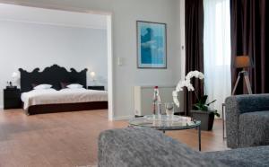 a living room with a bed and a glass table at Wyndham Hannover Atrium in Hannover +18 photos