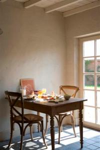 een tafel en twee stoelen in een kamer met een tafel en een raam bij B&B Hoeve de Steenoven in Damme