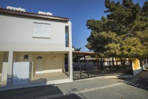 Biały dom z bramą i drzewem w obiekcie Larnaca Villa Marina w mieście Meneou