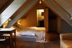 a bedroom with a bed in a attic at B&B Hoeve de Steenoven in Damme