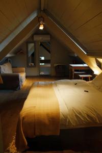 a large bed in a room with an attic at B&B Hoeve de Steenoven in Damme