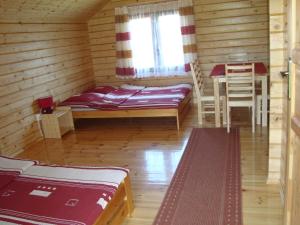 una habitación con una cama y una mesa en una cabaña en Domki "Na Dworskiej" Polańczyk 696-025-331 en Polańczyk