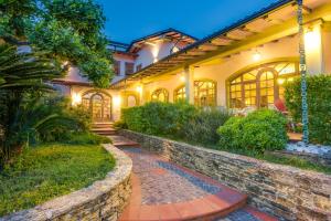 an estate with a stone walkway in front of a house at Hotel Il Buongustaio in Massa