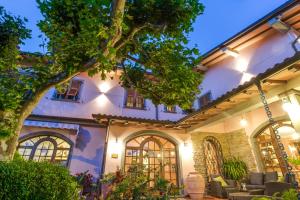 una vista exterior de un edificio con un árbol en Hotel Il Buongustaio, en Massa