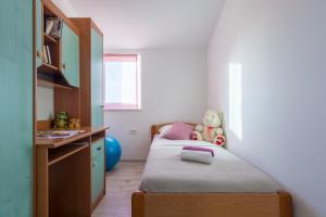 a small bedroom with two beds and a desk at Apartman Berto in Vrsi +15 photos