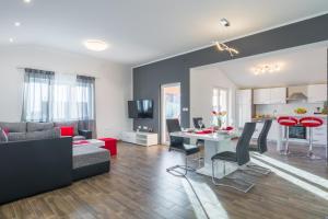 a living room with a couch and a table with chairs at Apartman Berto in Vrsi