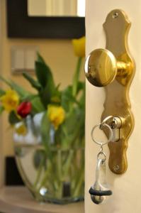 une poignée de porte en or avec un vase de fleurs dans l'établissement Hotel Bova, à Francfort-sur-le-Main