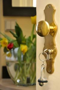 a gold door handle with a vase of flowers at Hotel Bova in Frankfurt