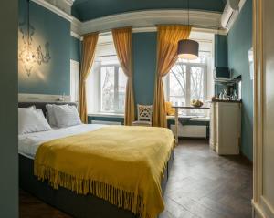 a bedroom with a bed with a yellow blanket at Apart Hotel Michelle in Odesa