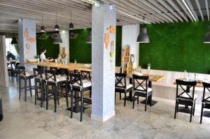 a restaurant with a bar with black chairs and green walls at Central Apartment in Stara Zagora