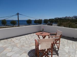 a table and chairs on a patio with a view of the ocean at Agali Apartments in Tinos Town