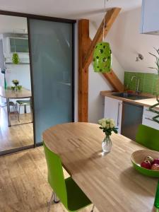 a kitchen and dining room with a wooden table and green chairs at Apartment 23 in Český Krumlov
