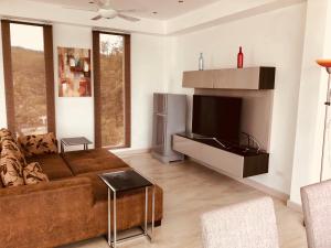 a living room with a couch and a television at Chiang Khan Riverside Pool Villa in Chiang Khan