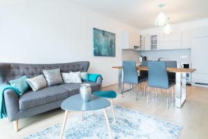 salon z szarą kanapą i niebieskimi krzesłami w obiekcie Vienna Residence | Spacious Serviced Apartment in Vienna directly at the U4 w Wiedniu