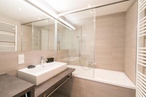 W łazience znajduje się umywalka, prysznic i wanna. w obiekcie Vienna Residence | Spacious Serviced Apartment in Vienna directly at the U4 w Wiedniu