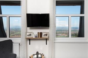 un soggiorno con 2 finestre e una TV a schermo piatto di NA KRÁSNÉ VYHLÍDCE a Olšina