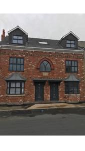 a red brick building with black doors and windows at Joe Kelly Buildings B in Withernsea