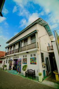 a white building with paintings on the side of it at Antic Guesthouse - Galle Fort in Galle