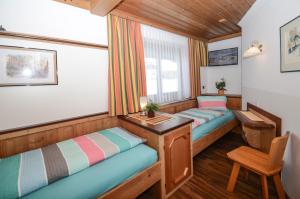 Pokój z 2 łóżkami i biurkiem w obiekcie MH Appartement Hochwimmer w Saalbach Hinterglemm