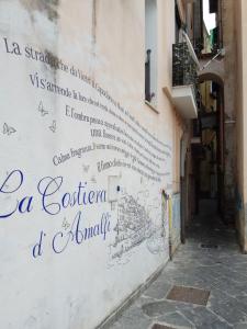 eine Wand mit Schreiben an der Seite eines Gebäudes in der Unterkunft B&B degli Amalfitani in Salerno