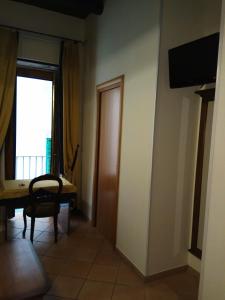 a room with a table and a chair and a window at Amalfitani Salerno Centro in Salerno