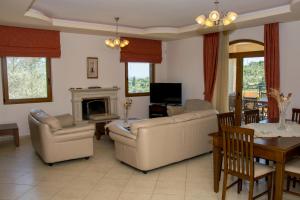 sala de estar con sofás y comedor en Villa Tinadora en Agia Triada