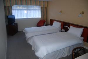 Habitación de hotel con 2 camas y TV en Brecon Hotel Sheffield Rotherham en Rotherham