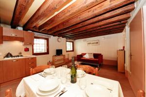 ein Esszimmer mit einem Tisch und einer Küche in der Unterkunft Ca' Bernarda in Venedig
