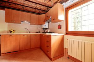 eine Küche mit Holzschränken und einem Fenster in der Unterkunft Ca' Bernarda in Venedig