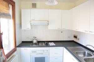 a kitchen with white cabinets and a stove top oven at Bocca di Piazza in Venice