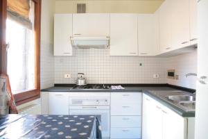 a white kitchen with white cabinets and a sink at Bocca di Piazza in Venice