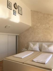 a bed with white sheets and pillows in a room at SiMa in Baška Voda