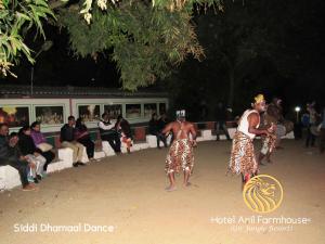 dos mujeres bailando delante de un grupo de personas en Hotel Anil Farmhouse Gir Jungle Resort, en Sasan Gir