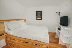 1 Schlafzimmer mit einem weißen Bett und einem TV in der Unterkunft Villa Una Vlasic in Vlasic
