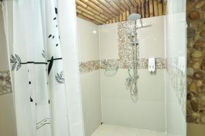 La salle de bains est pourvue d'une douche avec rideau de douche. dans l'établissement Mek Kiri Riverkwai Resort SHA, à Thong Pha Phum