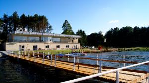 a building on a dock next to a body of water at Kaszubówka 29 in Załakowo