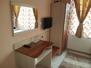 a room with a wooden desk and a mirror at Family Hotel Zhelkovi - Olympia in Kharmanli