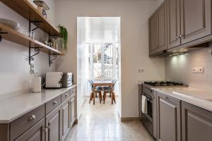 a kitchen with white cabinets and a table in it at Luxury at Liberdade - In the heart of Lisbon in Lisbon