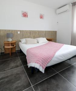 a bedroom with a bed with a pink blanket on it at Macchie e Fiori in Pianottoli-Caldarello