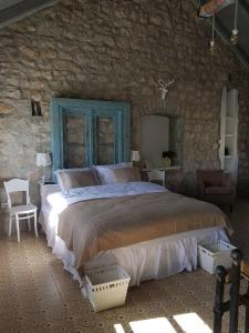 トレビニェにあるKamena kuća-Stone houseの石壁のベッドルーム1室(大型ベッド1台付)